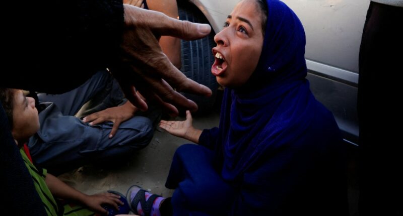 Woman mourning at hospital after deadly incident in Gaza.