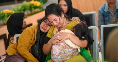 Grieving family members await updates at a port.