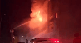 Firefighters battling a large building fire at night.