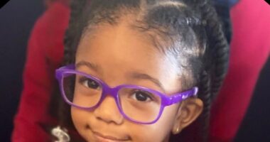 Portrait of a young girl wearing purple glasses.