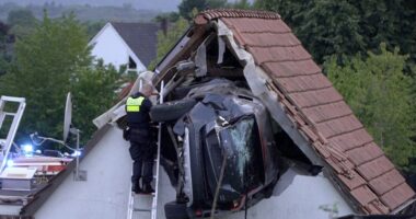 Police officer investigating a car crashed into a house.