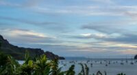 Tropical bay with sailboats at sunset.