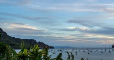 Tropical bay with sailboats at sunset.