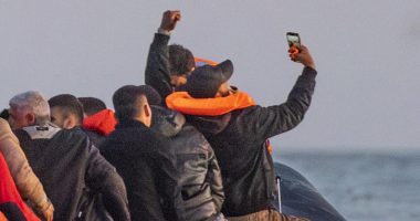 Migrants in a small boat taking a selfie while crossing the English Channel.