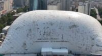 Aerial view of a large inflatable dome covering a construction site in a city.
