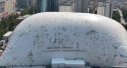 Aerial view of a large inflatable dome covering a construction site in a city.