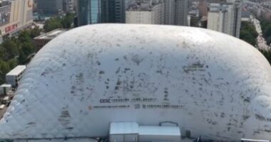 Aerial view of a large inflatable dome covering a construction site in a city.