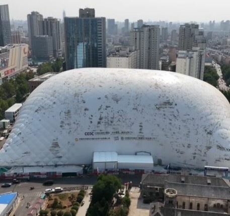 Aerial view of a large inflatable dome covering a construction site in a city.