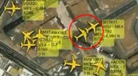 Aerial view of airport with multiple airplanes and flight information overlaid.