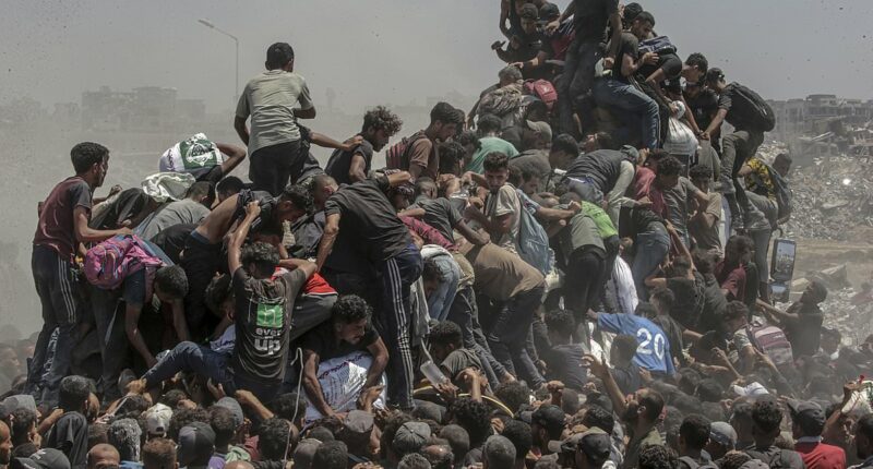 Desperate Palestinians descend on aid trucks in Gaza
