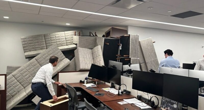 Office workers barricade their workspace with furniture.