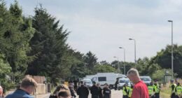 Police officers blocking a road.