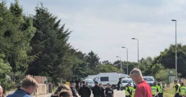Police officers blocking a road.