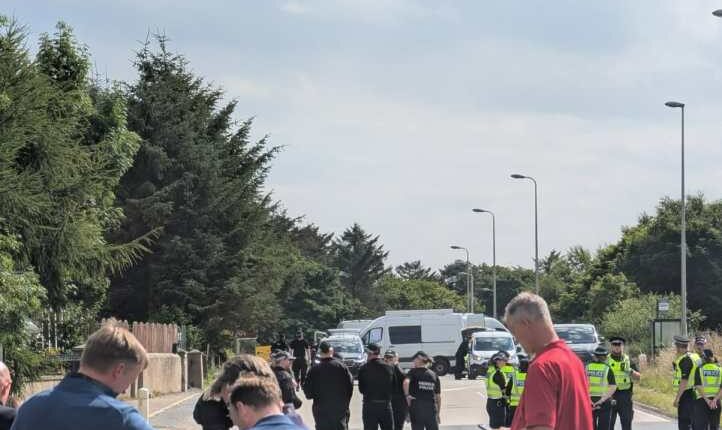 Police officers blocking a road.