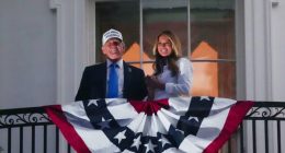 Donald and Melania Trump on a White House balcony with an American flag.