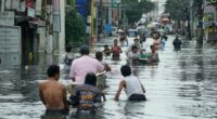 Residents wade through a flooded street in Malabon City, Philippines.