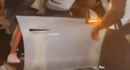 A gang surrounding a car, attacking the driver.