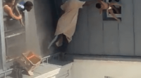 Man catching baby dropped from window.