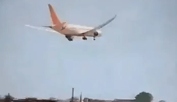 Airplane landing over houses.