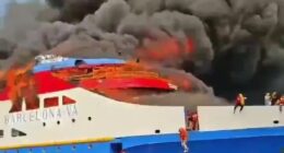 Burning ferry with people jumping into the ocean.