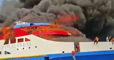 Burning ferry with people jumping into the ocean.
