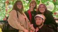 Photo of four friends in front of a Christmas tree.