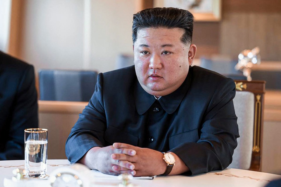 Kim Jong Un sitting at a table.