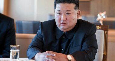 Kim Jong Un sitting at a table.