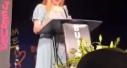 Teenage girl giving a speech at a podium.