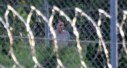 Ghislaine Maxwell seen through a fence at FCI Tallahassee.