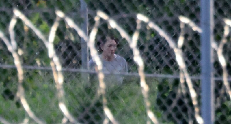 Ghislaine Maxwell seen through a fence at FCI Tallahassee.