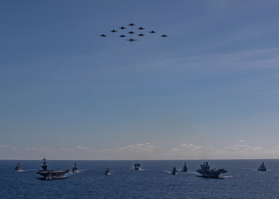 Aerial view of multiple warships sailing in formation.