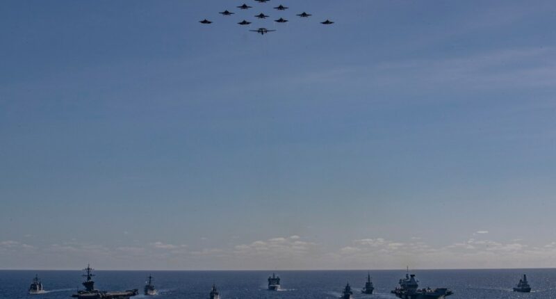 Aerial view of multiple warships sailing in formation.