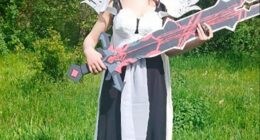 Woman in cosplay holding a large sword.