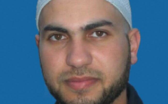 Headshot of a man wearing a kufi.