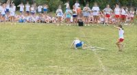 A girl falling during a field day event while other girls watch.