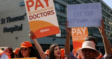 Resident doctors on strike holding signs advocating for better pay.