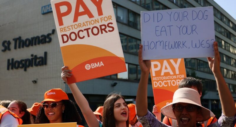 Resident doctors on strike holding signs advocating for better pay.