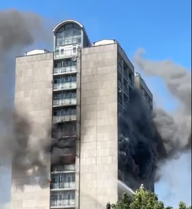 High-rise building engulfed in smoke and fire.