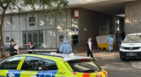 Crime scene with police and forensic officers.