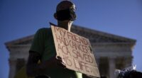 Protester holds sign that says 'My friend had cancer. ACA saved his life.'