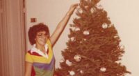 Young woman decorating a Christmas tree.