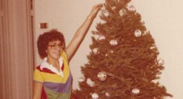 Young woman decorating a Christmas tree.