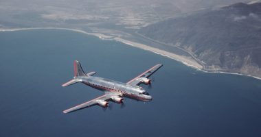 American Airlines Douglas DC-4 airplane in flight over ocean.