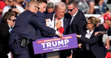 Donald Trump being helped off stage at a campaign event.