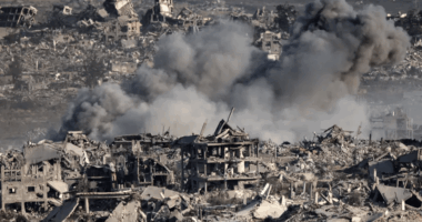 Bomb damage and smoke over rubble-strewn landscape.