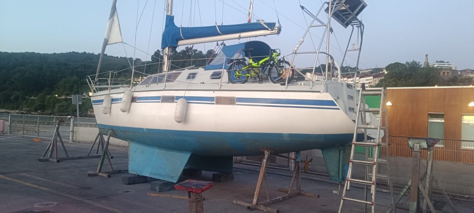 Sailboat on land with a bicycle on deck.