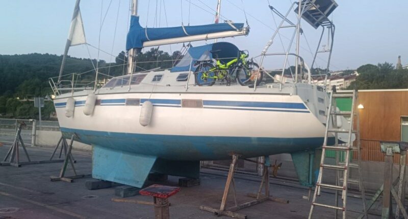 Sailboat on land with a bicycle on deck.