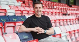 Gary Neville, Sage brand ambassador, sitting in stadium seats.