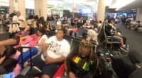 Large group of travelers waiting at LAX airport for a Honolulu flight.